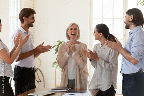 Canvas-taulu Happy employees applauding middle aged businesswoman executive, thanking excited