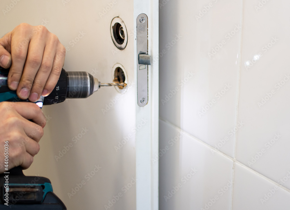 Naklejka premium repairing a door lock with a drill