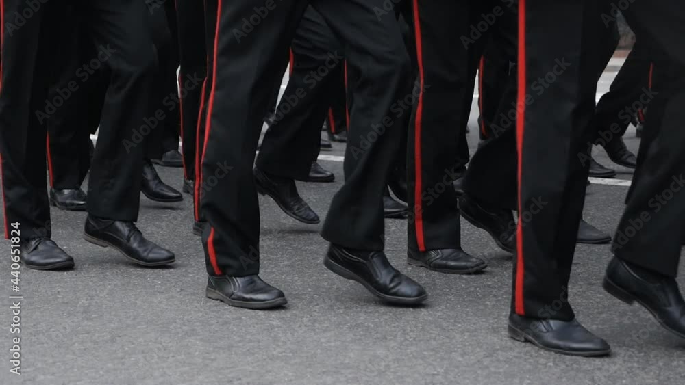 Close-up of legs and feet of military men marching down the street during the daytime parade in honor of veterans and military service. slow motion Close-up of legs and feet of military men marching down the street during the daytime parade in honor of veterans and military service. slow motion