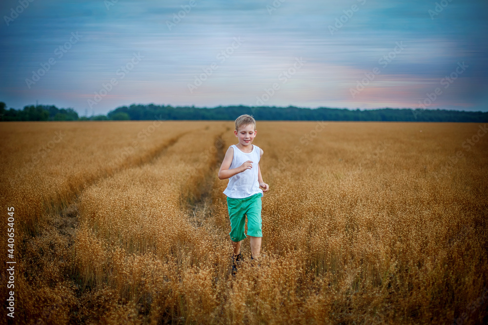a boy in a white T-shirt and green shorts runs across a field of ripe wheat a boy in a white T-shirt and green shorts runs across a field of ripe wheat
