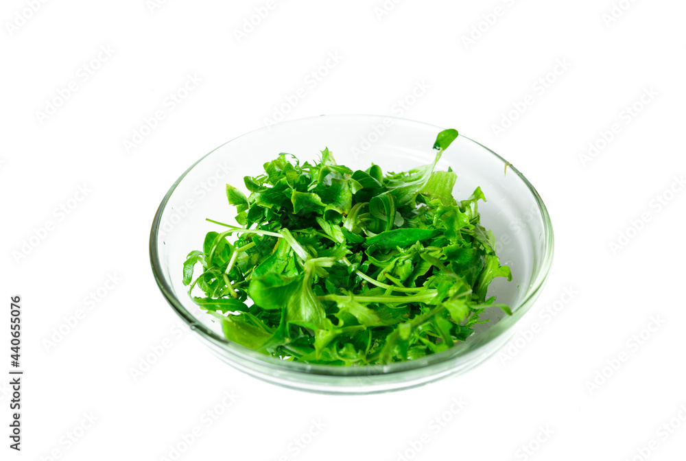 healthy food concept. arugula in transparent plate on a white isolated background. vegan food. healthy food concept. arugula in transparent plate on a white isolated background. vegan food.