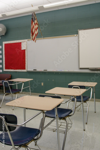 Empty classroom with desks and chairs and a white board.