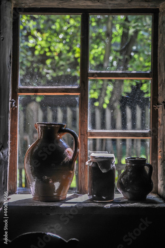dzbanki i słoik na oknie wiejskiej chaty