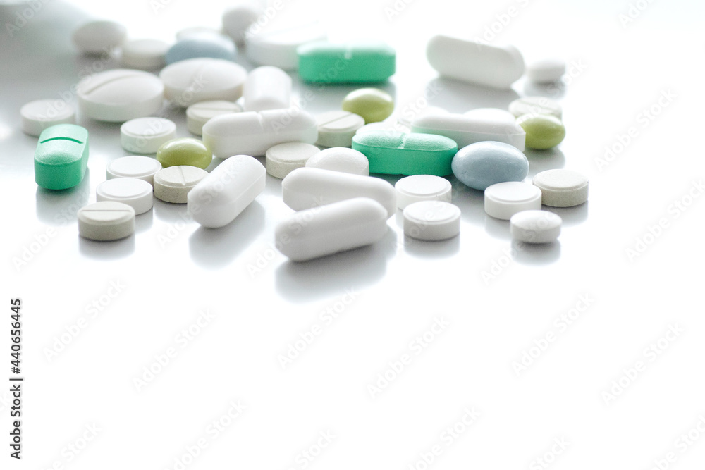 Colored pills are scattered on a white background. Medication treatment concept. Idea of a blog about health, vitamins, help with diseases. pharmacy business, benefits and harms of drugs. Colored pills are scattered on a white background. Medication treatment concept. Idea of a blog about health, vitamins, help with diseases. pharmacy business, benefits and harms of drugs.