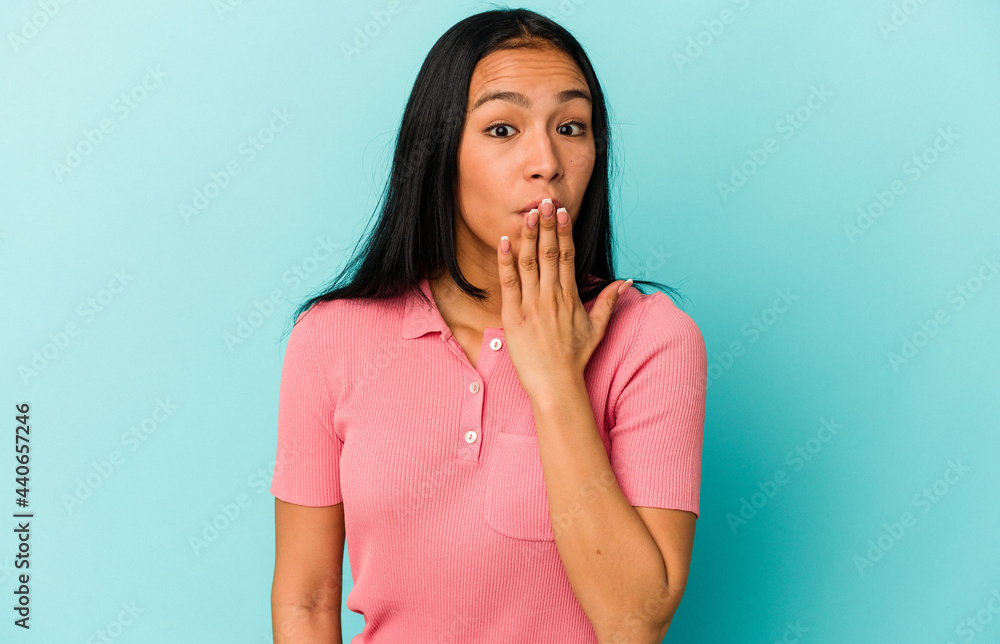 Young Venezuelan woman isolated on blue background shocked, covering mouth with hands, anxious to discover something new. Young Venezuelan woman isolated on blue background shocked, covering mouth with hands, anxious to discover something new.
