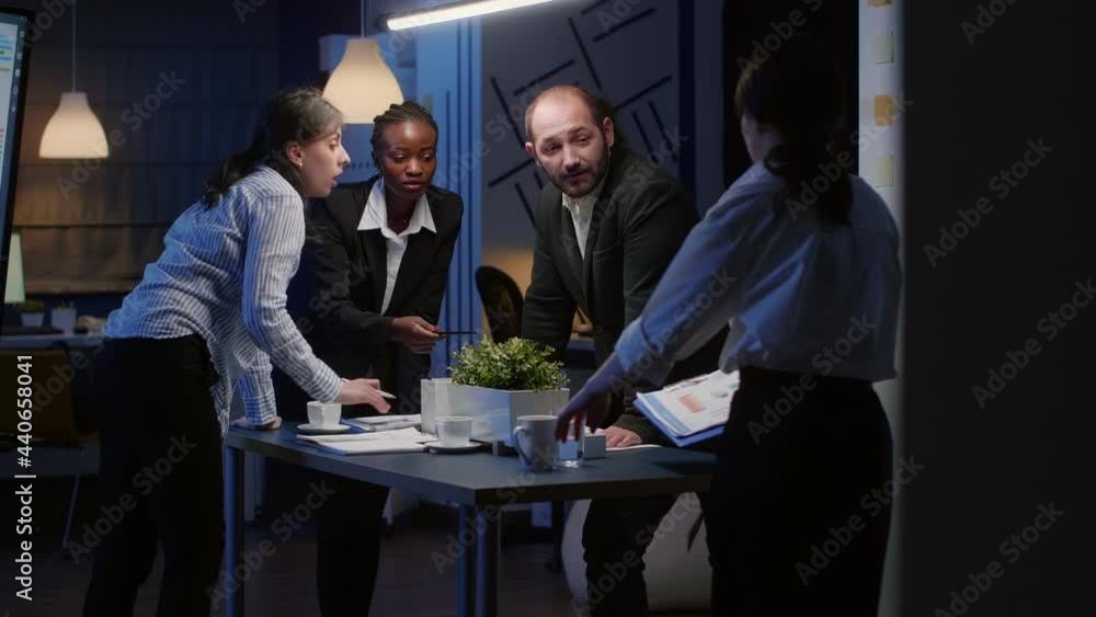 Focused businesswoman enter in office meeting room standing at conference table planning business company presentation late at night. Diverse multi ethnic teamwork discussing management strategy Focused businesswoman enter in office meeting room standing at conference table planning business company presentation late at night. Diverse multi ethnic teamwork discussing management strategy