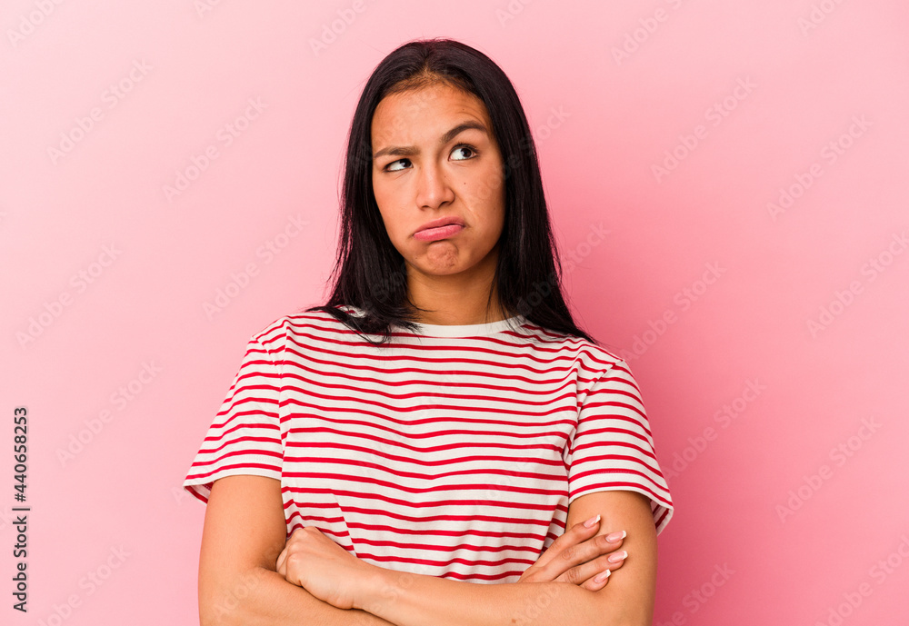 Obraz premium Young Venezuelan woman isolated on pink background tired of a repetitive task.