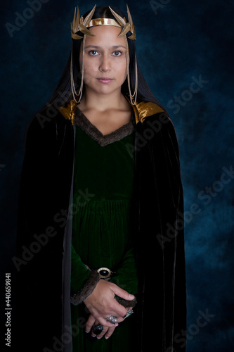 Medieval woman wearing a green velvet dress and velvet cloak