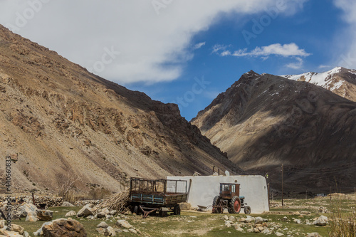 Village house and tractor in Gunt river valley in Pamir mountains, Tajikistan