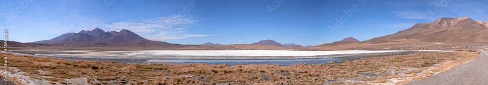 Huge panorama landscape of mountains and green lake with reflection and volcanos in natural habitat in atacama desert, uyuni salt flats, chile	