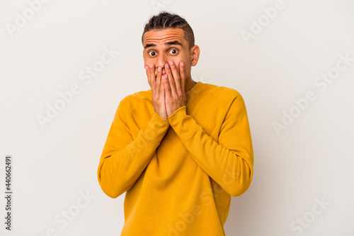 Young venezuelan man isolated on white background shocked, covering mouth with hands, anxious to discover something new.