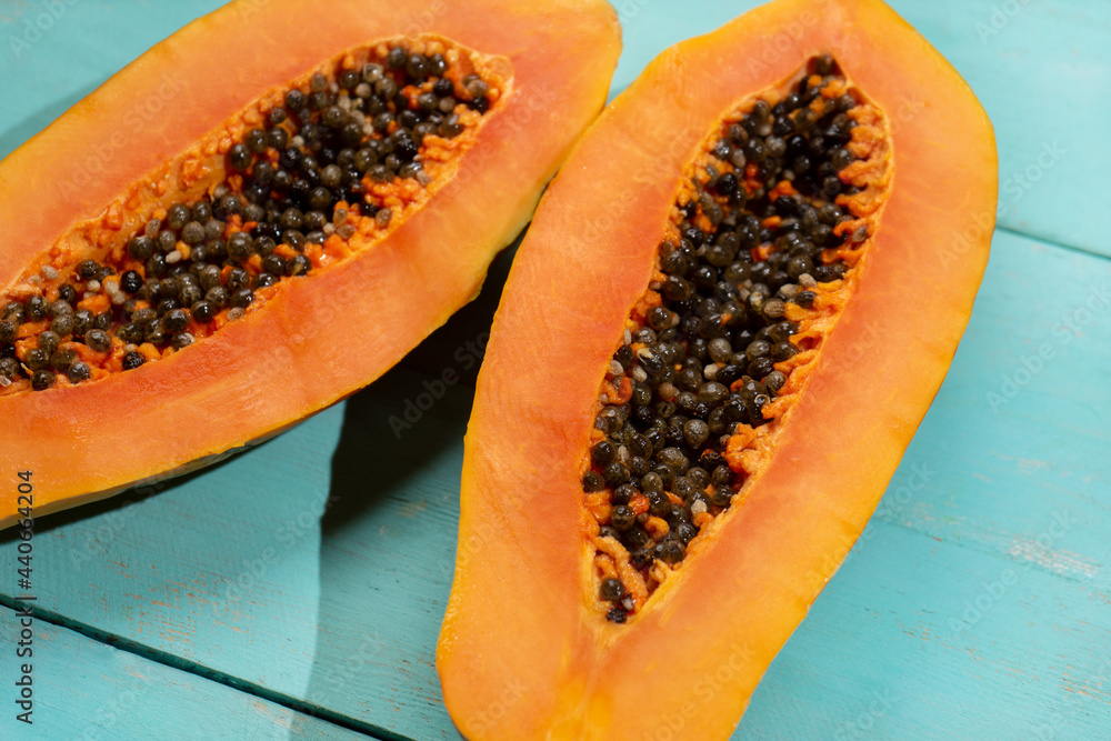Papaya fruit half on turquoise background