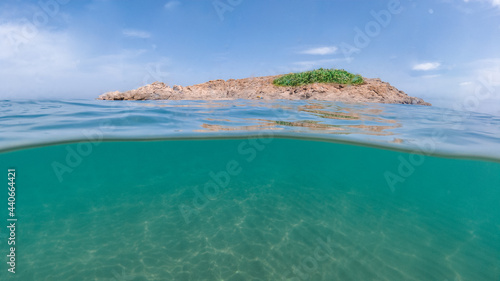 A view of an island half undersea and half of the shore of lonely island, half underwater and half of the island in the middle of Mediterranean sea, Swimming in crystal clear sea water, Jijel algeria.