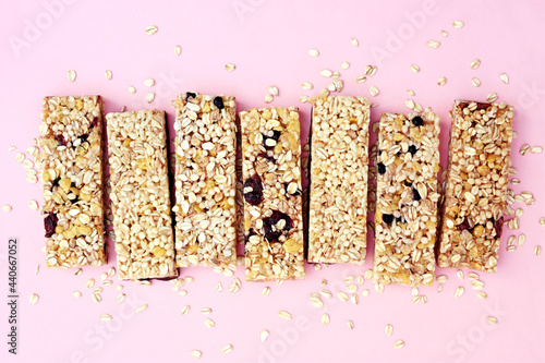 Granola bars on pink background, healthy muesli snack for diet breakfast, sweet dessert with oat, nuts and berries