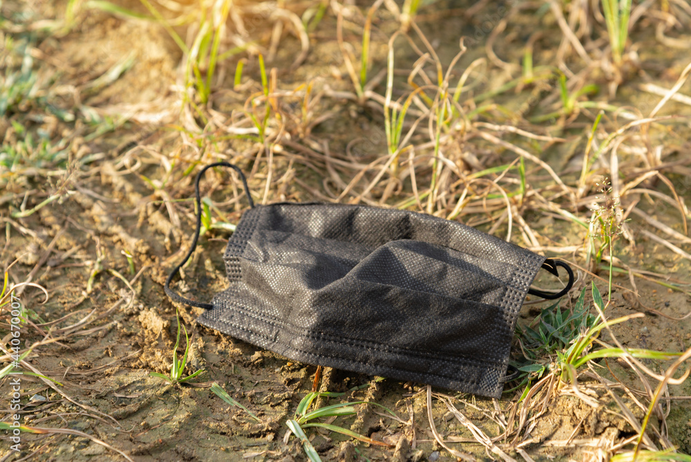 An used medical mask dumping on the ground. Coronavirus,Covid-19 and Environmental pollution concept. An used medical mask dumping on the ground. Coronavirus,Covid-19 and Environmental pollution concept.