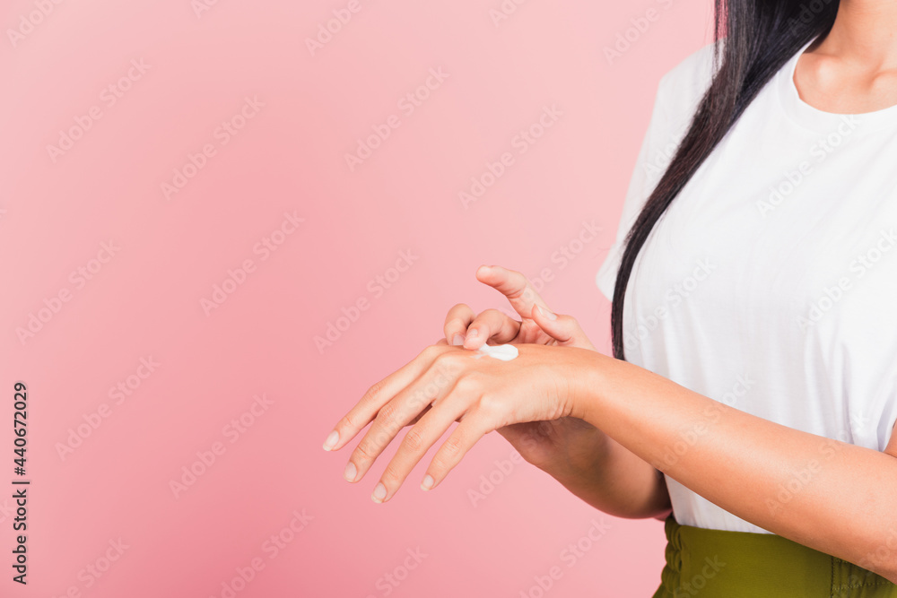 Portrait of Asian beautiful young woman applying lotion cosmetic moisturizer cream on her behind the palm skin back hand, studio shot isolated on pink background, Hygiene skin body care concept Portrait of Asian beautiful young woman applying lotion cosmetic moisturizer cream on her behind the palm skin back hand, studio shot isolated on pink background, Hygiene skin body care concept