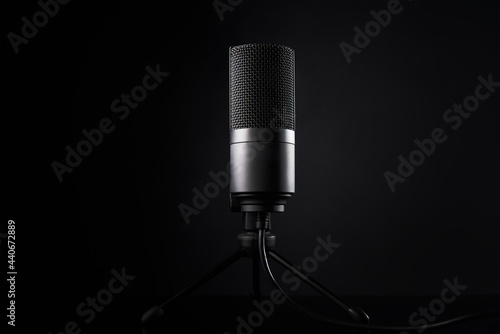 Studio microphone on dark background with copy space. Black professional condencer microphone. Podcast recording photo