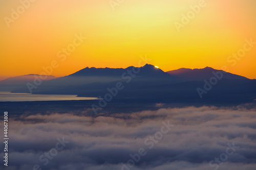 オレンジ色の夜明けの空の下の雲海と明媚な風景。