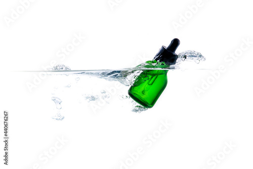 Green glass bottles with dropper splash of waterasia, background, bottle, celebration, color, concept, container, decoration, design, drink, dropper, equipment, glass, green, isolated, light, liquid,  photo