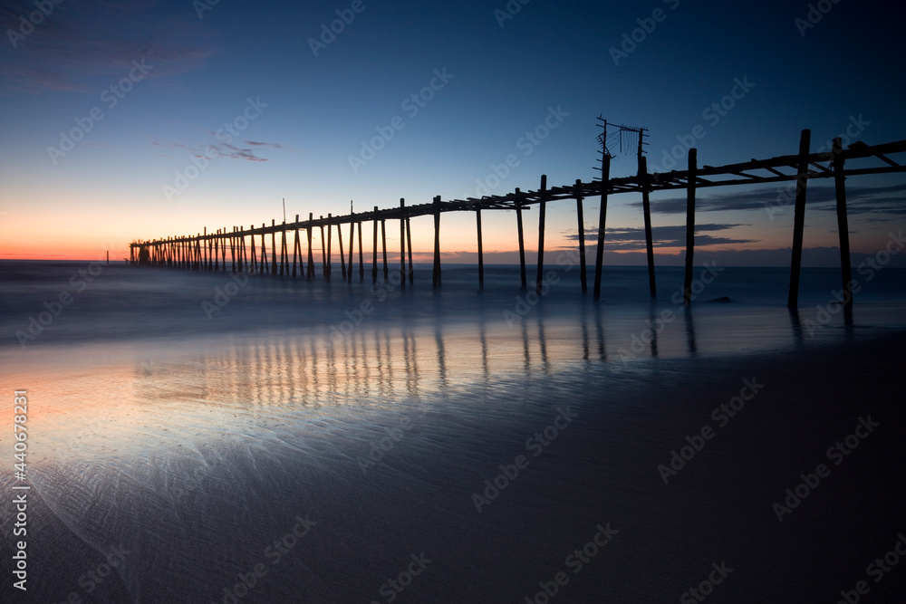Wooden bridge in the seaside with sunset