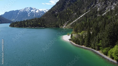 Hiking trail alongside the beautiful lake Achen. Beautiful mountains around and peaks covered with snow. Drone, aerial view of alpine nature. photo