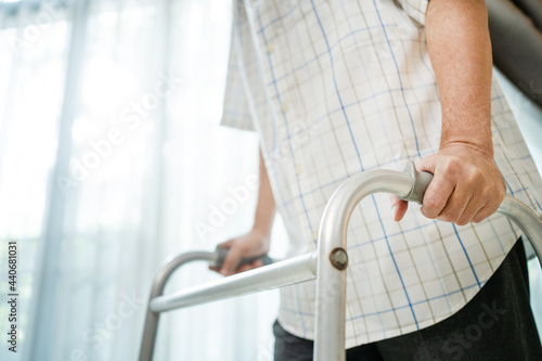 Close up hand of disabled man patient walk slowly with walker at home.