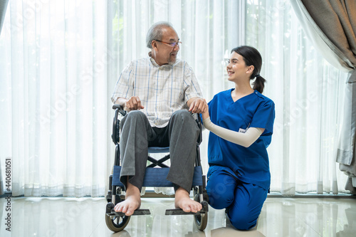 Portrait of older disabled man on wheelchair with nurse look at camera