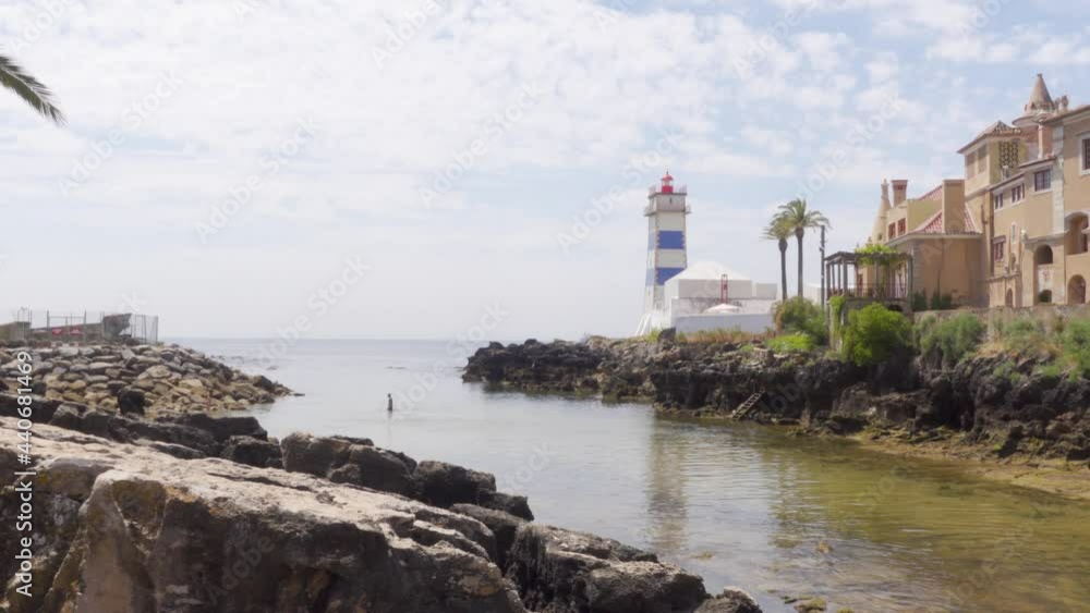 A Person in the Water by the Santa Marta Lighthouse in Cascais, Portugal A Person in the Water by the Santa Marta Lighthouse in Cascais, Portugal