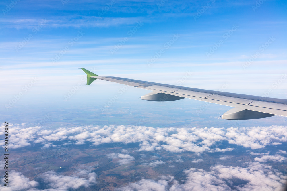 View from the airplane window at a beautiful blue sunrise and the airplane wing above the clouds. View from the airplane window at a beautiful blue sunrise and the airplane wing above the clouds.