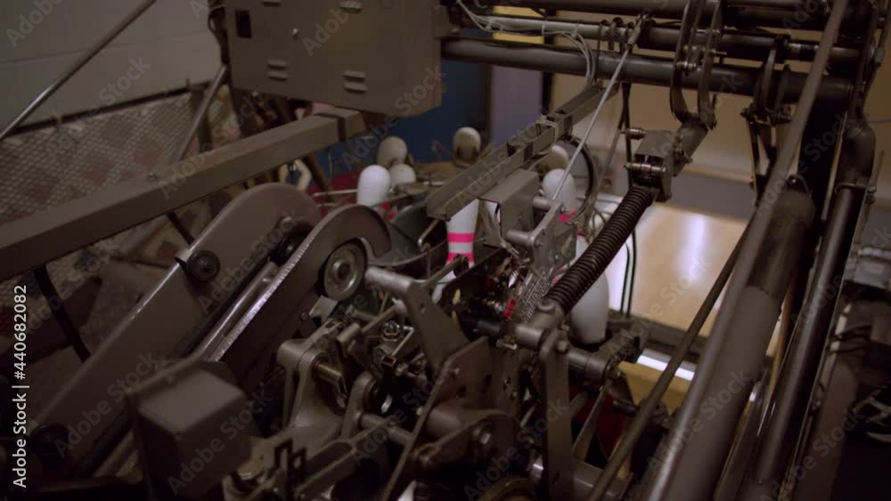 Bowling pins being reset by a pinsetter machine at a bowling alley