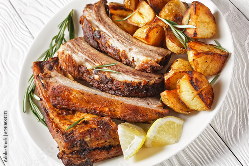 grilled pork ribs served with roast new potatoes photo