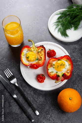 Fried eggs in red peppr on a white plate and dark grey table. photo