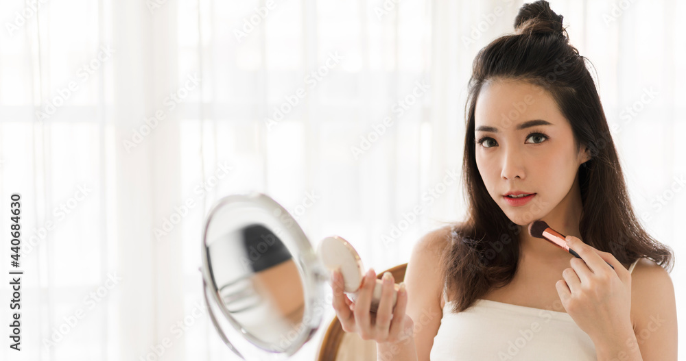 Smiling of young beautiful pretty asian woman clean fresh healthy white skin looking at camara.asian girl holding make-up brushes and make up on face with cosmetic set at home.facial beauty Smiling of young beautiful pretty asian woman clean fresh healthy white skin looking at camara.asian girl holding make-up brushes and make up on face with cosmetic set at home.facial beauty