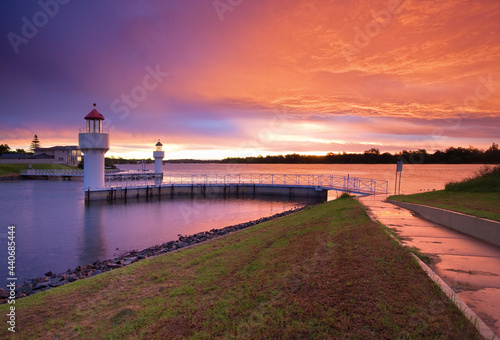 A dramatic sunset over an inland river with two lighthouse beacons photo