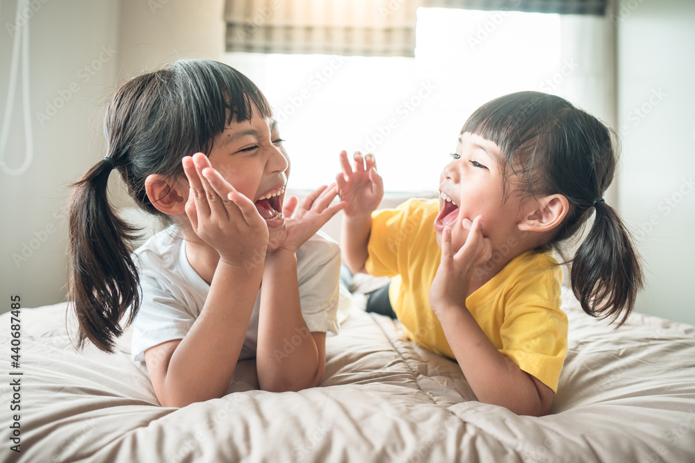 Cute asian children lying on the bed