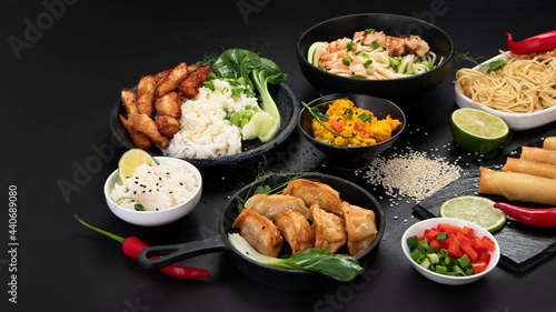 Assorted asian dishes and snacks on black background. Traditional food concept.
