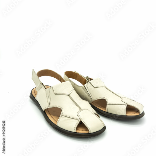 Open sandals for men made of light beige leather. Flat sole. Close-up. Isolated on white background