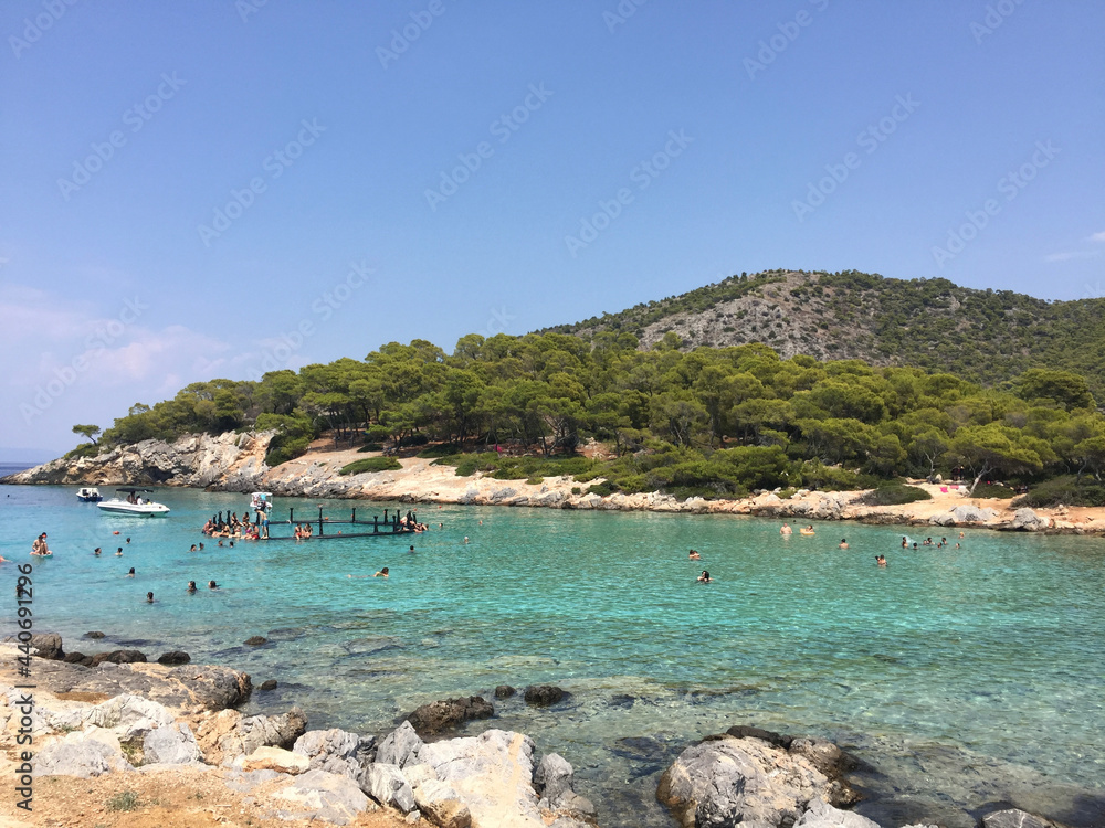 Aponisos beach, a pebble beach in a small cove with sheltered swimming, seen from Aponisos Island in the vicinity of Agistri, Greece. 