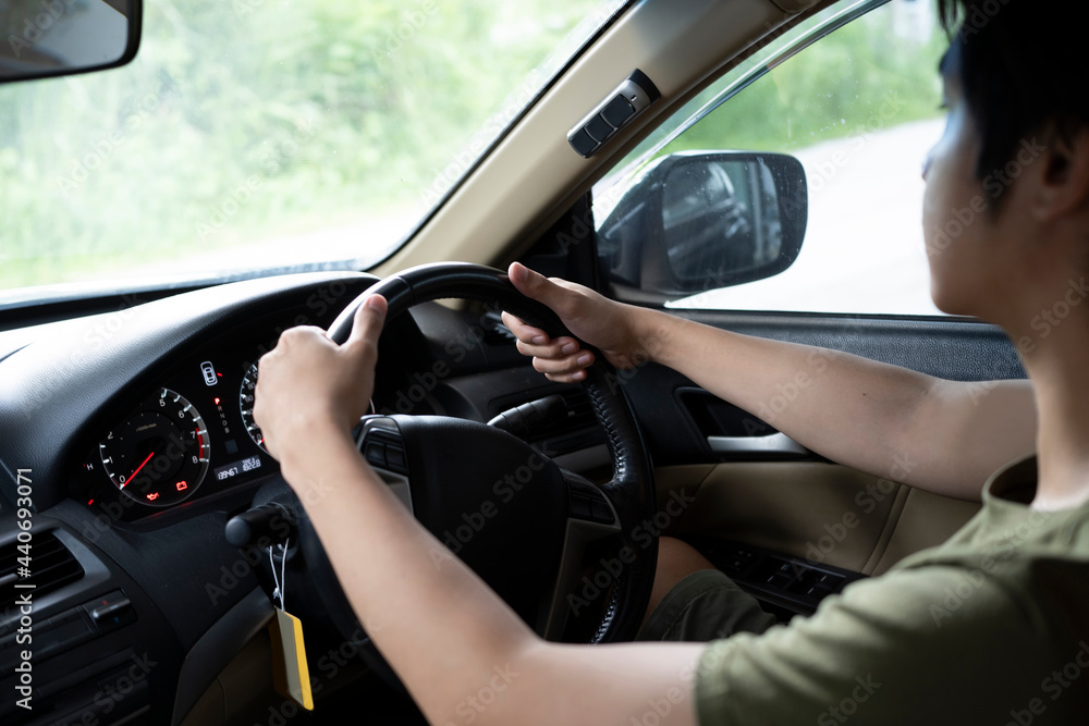 Cropped shot of young asian man driving car. Cropped shot of young asian man driving car.