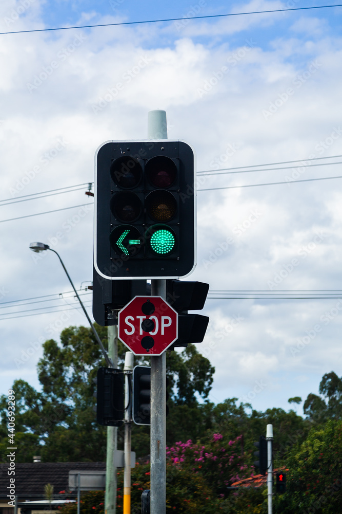 traffic light with green arrow and stop sign at city intersection Stock