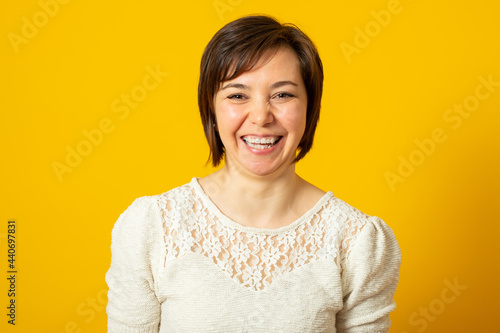 Laughing woman with crooked teeth in a stylish sweater smiles and happy.