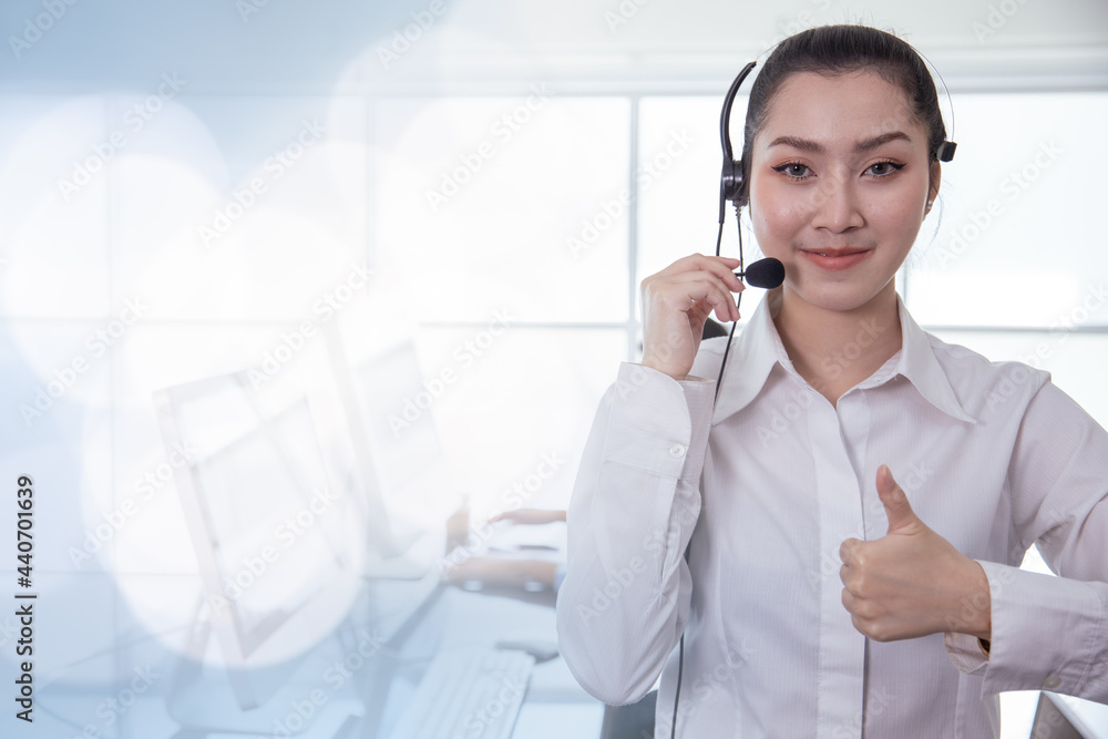 Portrait Asian callcenter operator thumbs up. Helpdesk support phone call customer care female staff smiling with headset good service concept with space for banner background. Portrait Asian callcenter operator thumbs up. Helpdesk support phone call customer care female staff smiling with headset good service concept with space for banner background.