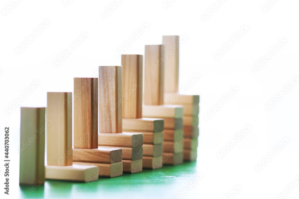 Stick wood block standing on stacked square wood blocks, abstract background in concept of winning, success, challenge, step to top position.