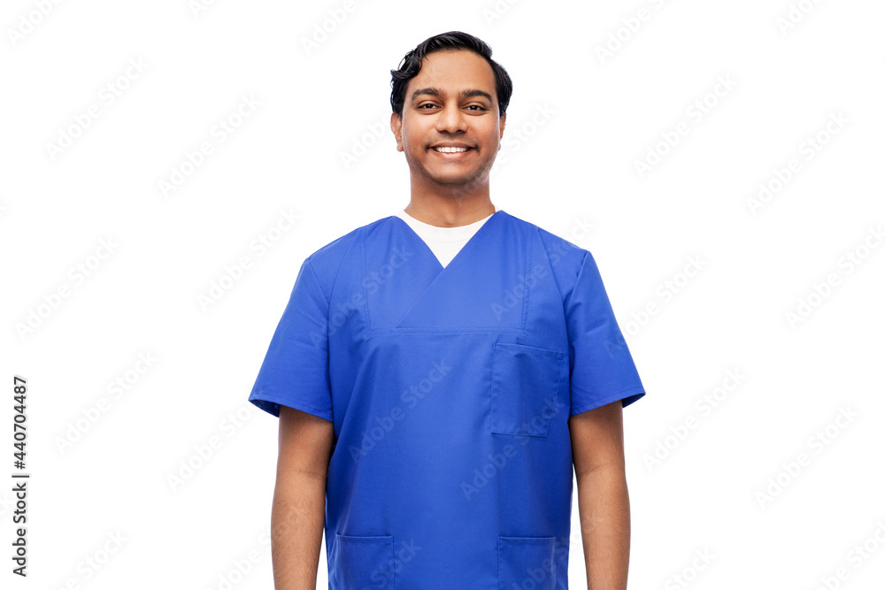 healthcare, profession and medicine concept - happy smiling indian doctor or male nurse in blue uniform over white background healthcare, profession and medicine concept - happy smiling indian doctor or male nurse in blue uniform over white background