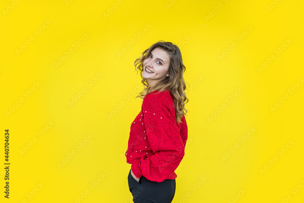 fashion woman in classic red knitted sweater posing and smiling on yellow background fashion woman in classic red knitted sweater posing and smiling on yellow background