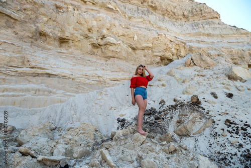 woman posing in background of mountain of sand, summer lifestyle
