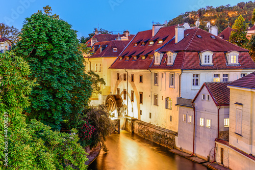 Photography An illuminated Certovka canal in with the water wheel in the historical city of Prague