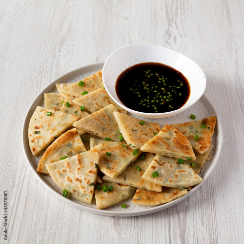 Homemade Scallion Pancakes with Soy Dipping Sauce on a white wooden background, low angle view. © Liudmyla
