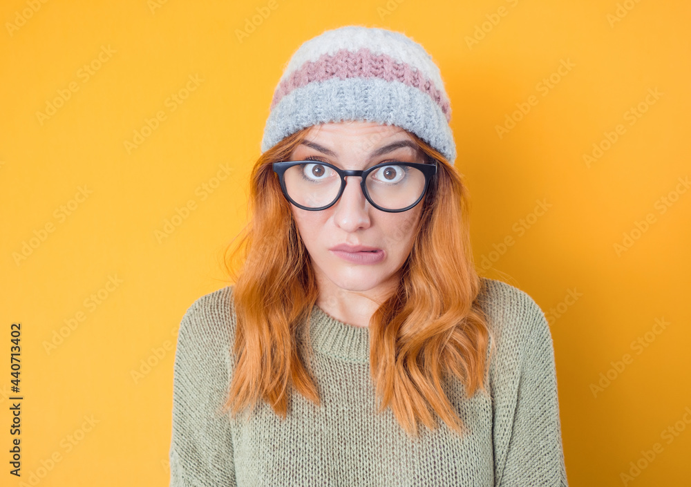 Confused young woman, isolated on yellow background. Girl with funny mouth grimace