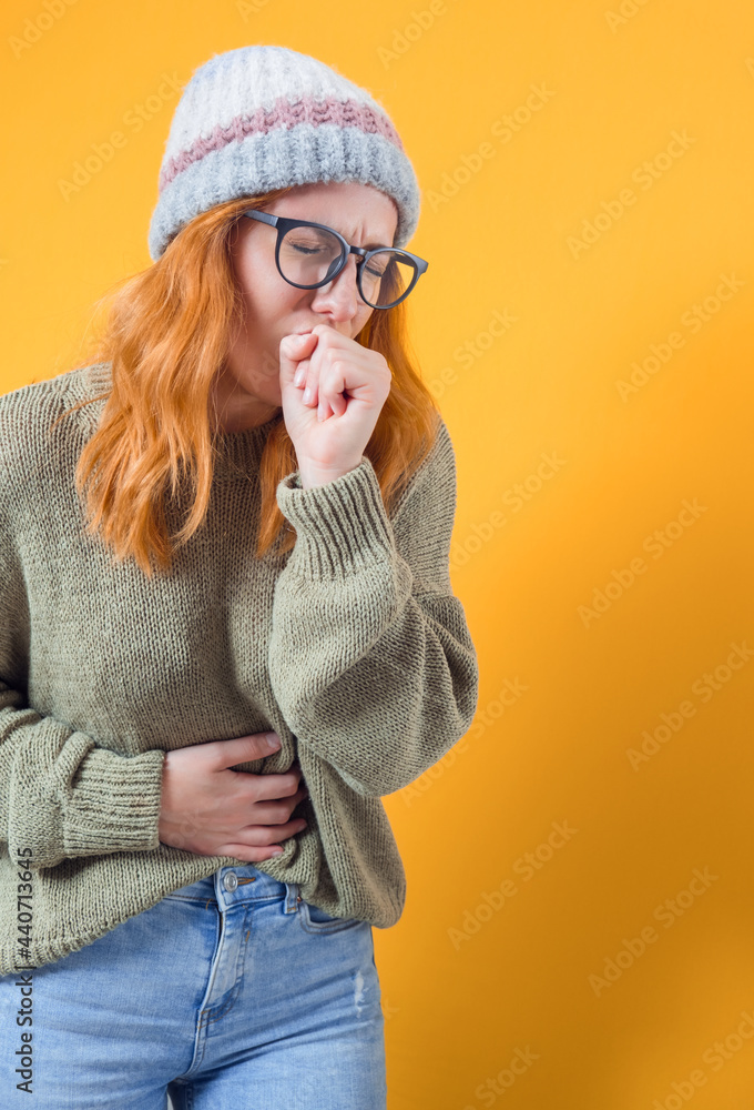 Young woman feeling ill with a sore throat and flu symptoms, coughing with mouth covered, isolated on white background Young woman feeling ill with a sore throat and flu symptoms, coughing with mouth covered, isolated on white background